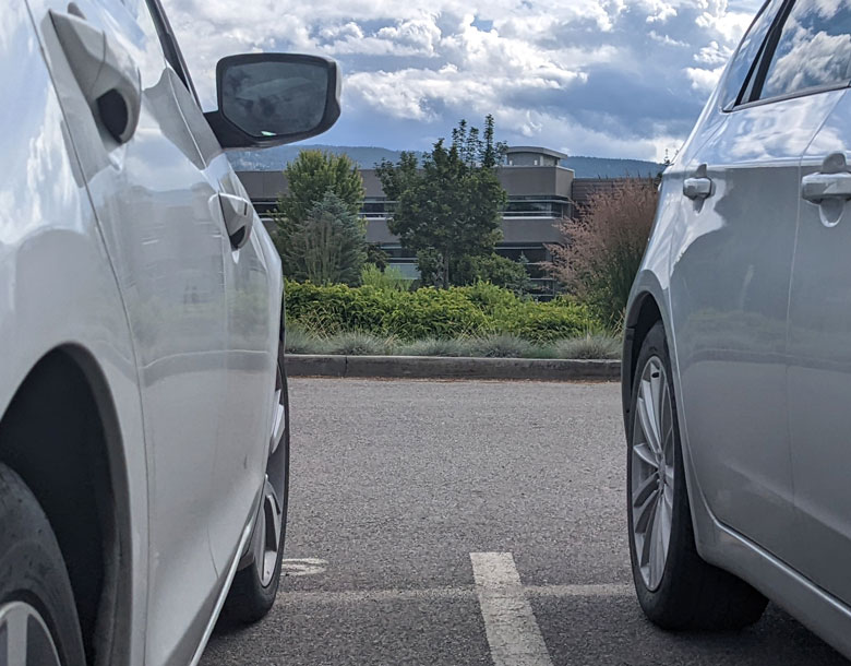 Two parked cars with FIPKE building in the background